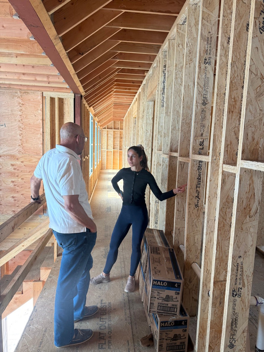 Rachel walking a builder through a framed wall on site